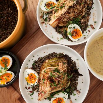 Overhead view of warm mustard lentils with charred cabbage, jammy eggs and garlic breadcrumbs in a shallow bowl