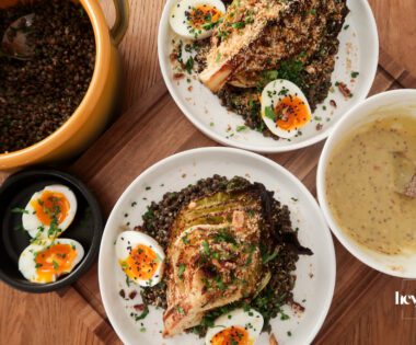 Overhead view of warm mustard lentils with charred cabbage, jammy eggs and garlic breadcrumbs in a shallow bowl