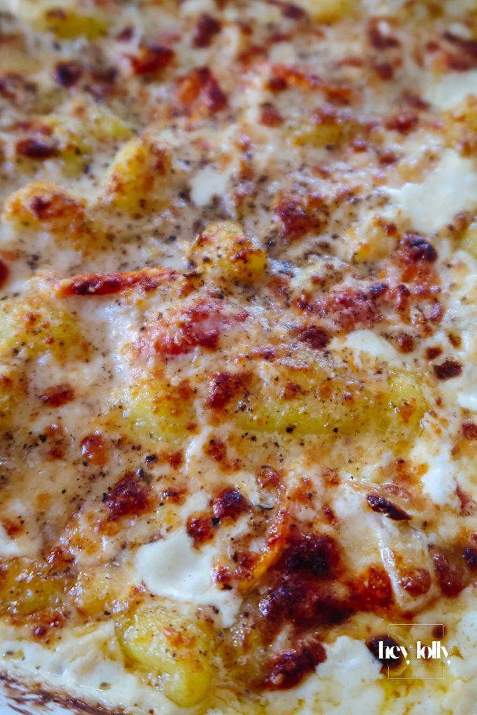 One-pot salmon and fennel gnocchi bake in an oven dish with golden Parmesan topping and burst cherry tomatoes