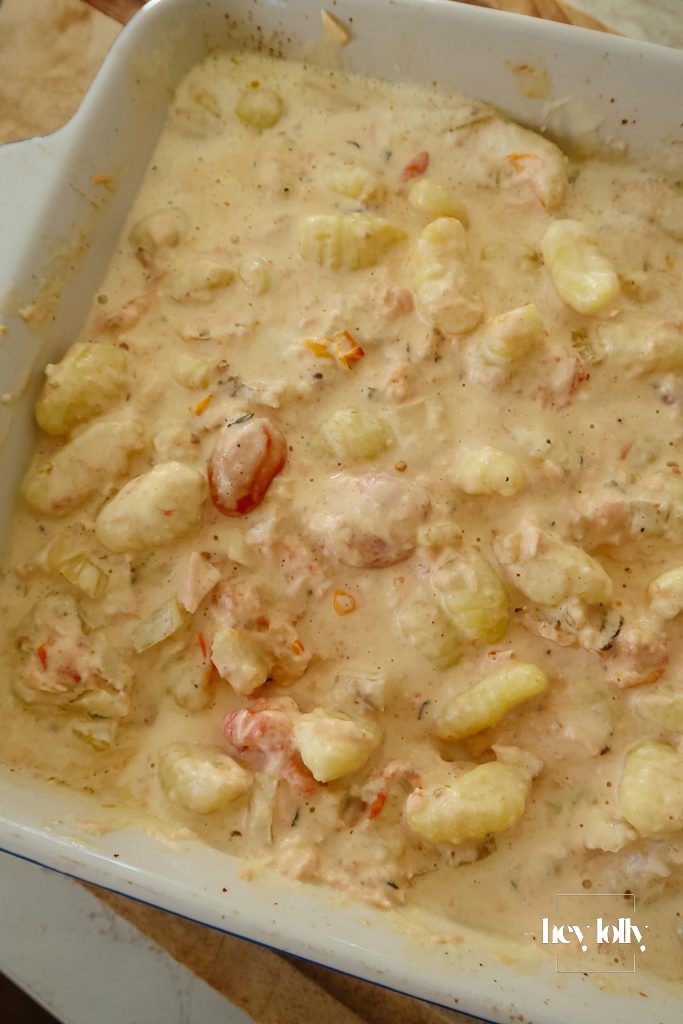 Overhead view of salmon and fennel gnocchi bake with bubbling creamy sauce and crisp Parmesan top