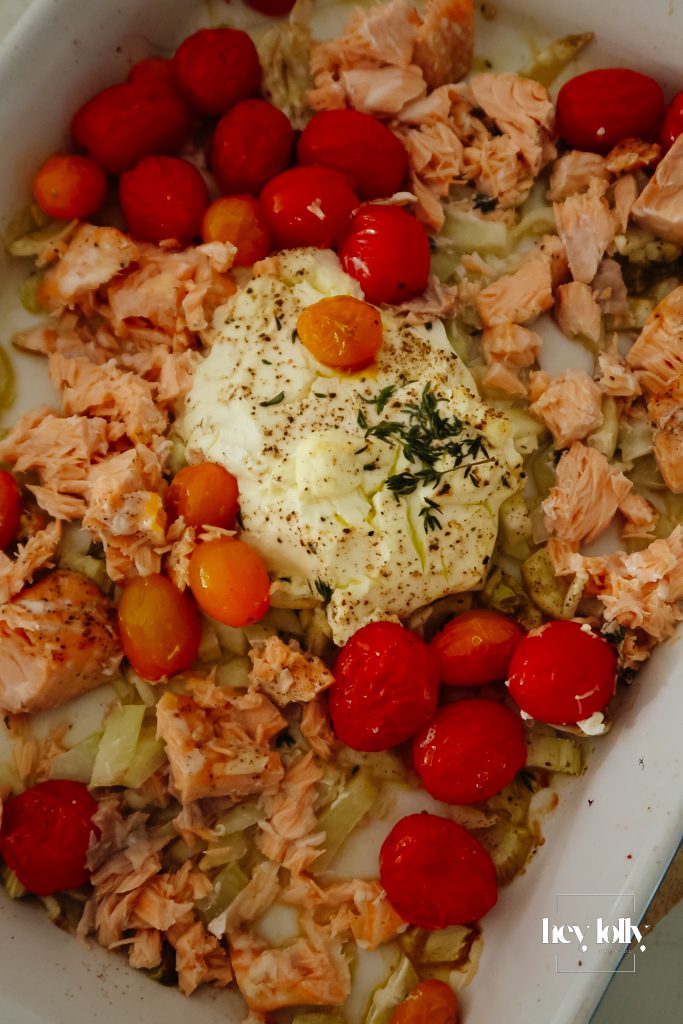 Cream cheese and crème fraîche dotted around the dish for salmon and fennel gnocchi bake before baking