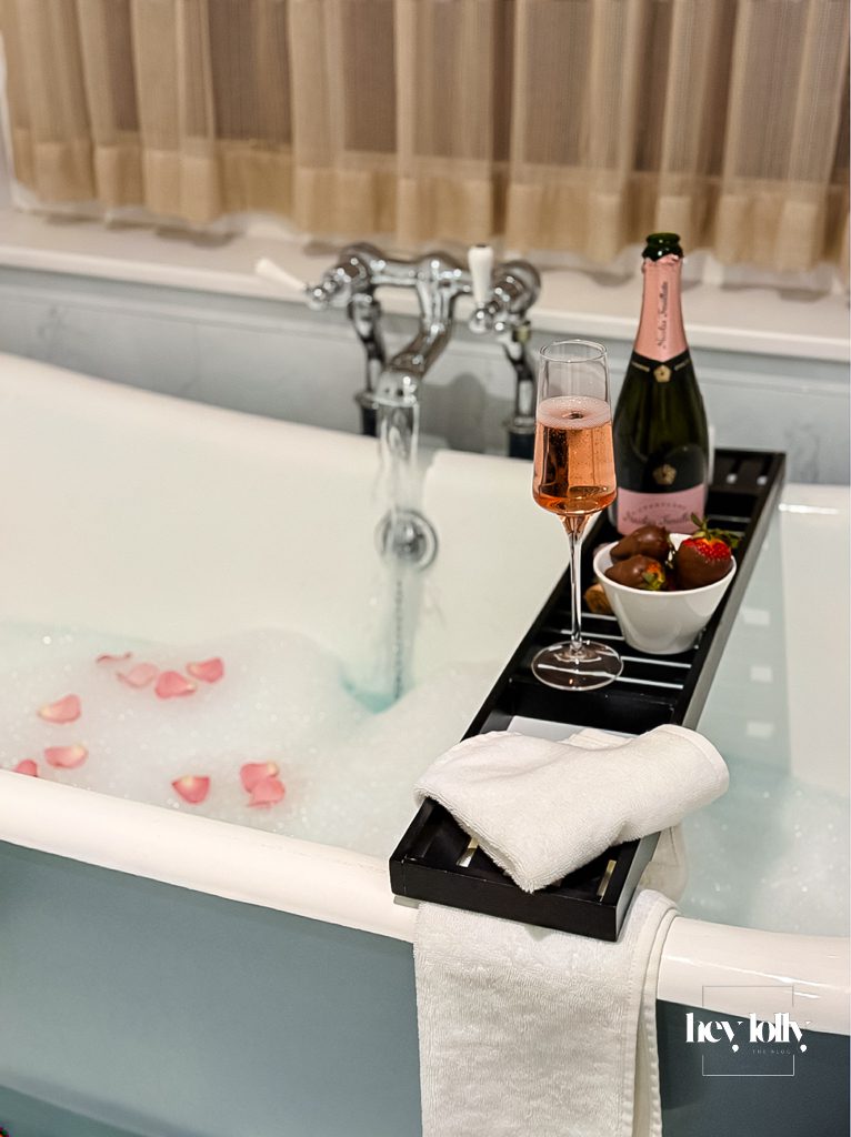 Champagne and chocolate-covered strawberries beside soaking tub