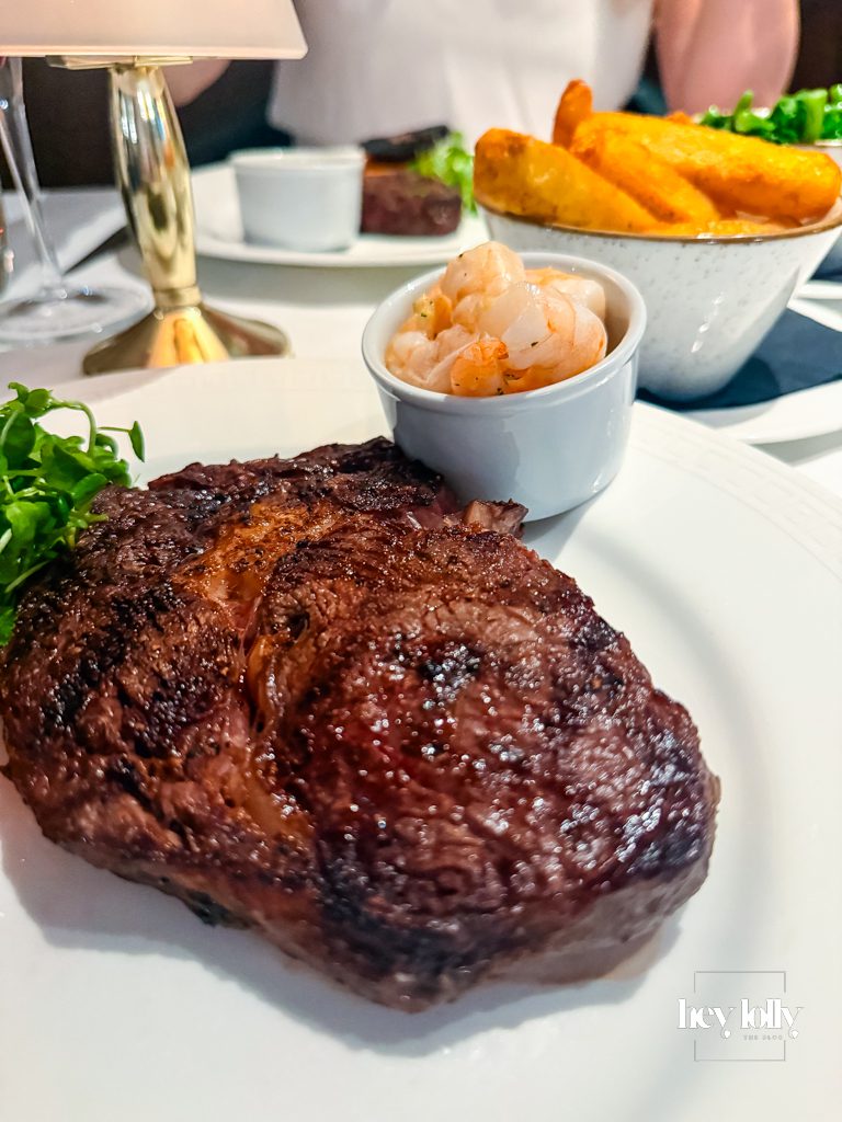 Grilled sirloin steak with triple-cooked chips and garlic butter prawns
