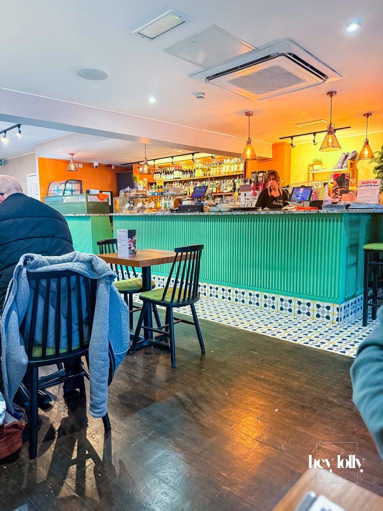 Warm interior of Bistro 66 in Beeston with green bar tiles, pendant lighting and relaxed brunch atmosphere