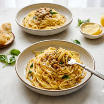 Preserved lemon pasta with roasted walnut pesto, basil and grated parmesan in a ceramic bowl