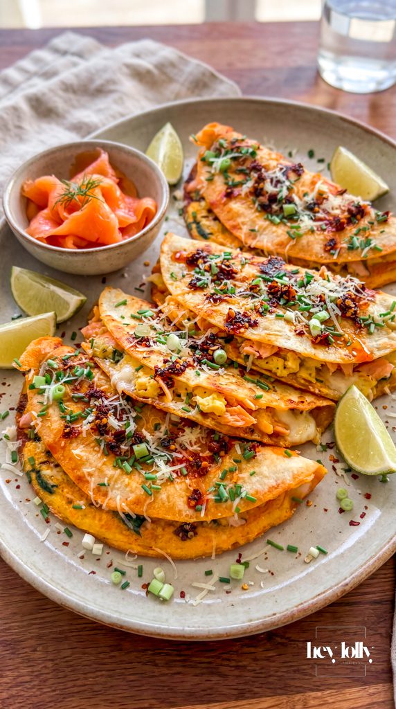Smoked salmon breakfast quesadilla with chilli crisp, melted cheese, spinach and chives on a platter