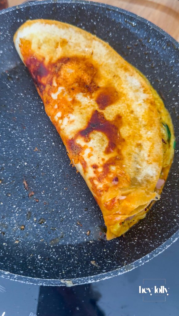 Quesadilla crisping in pan with golden tortilla and melted cheese